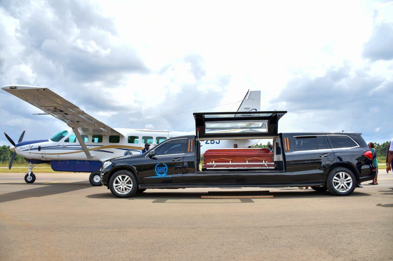Mercedes-Benz GL 550 Limousine Hearse parked on an airport tarmac beside a light aircraft during a repatriation handover