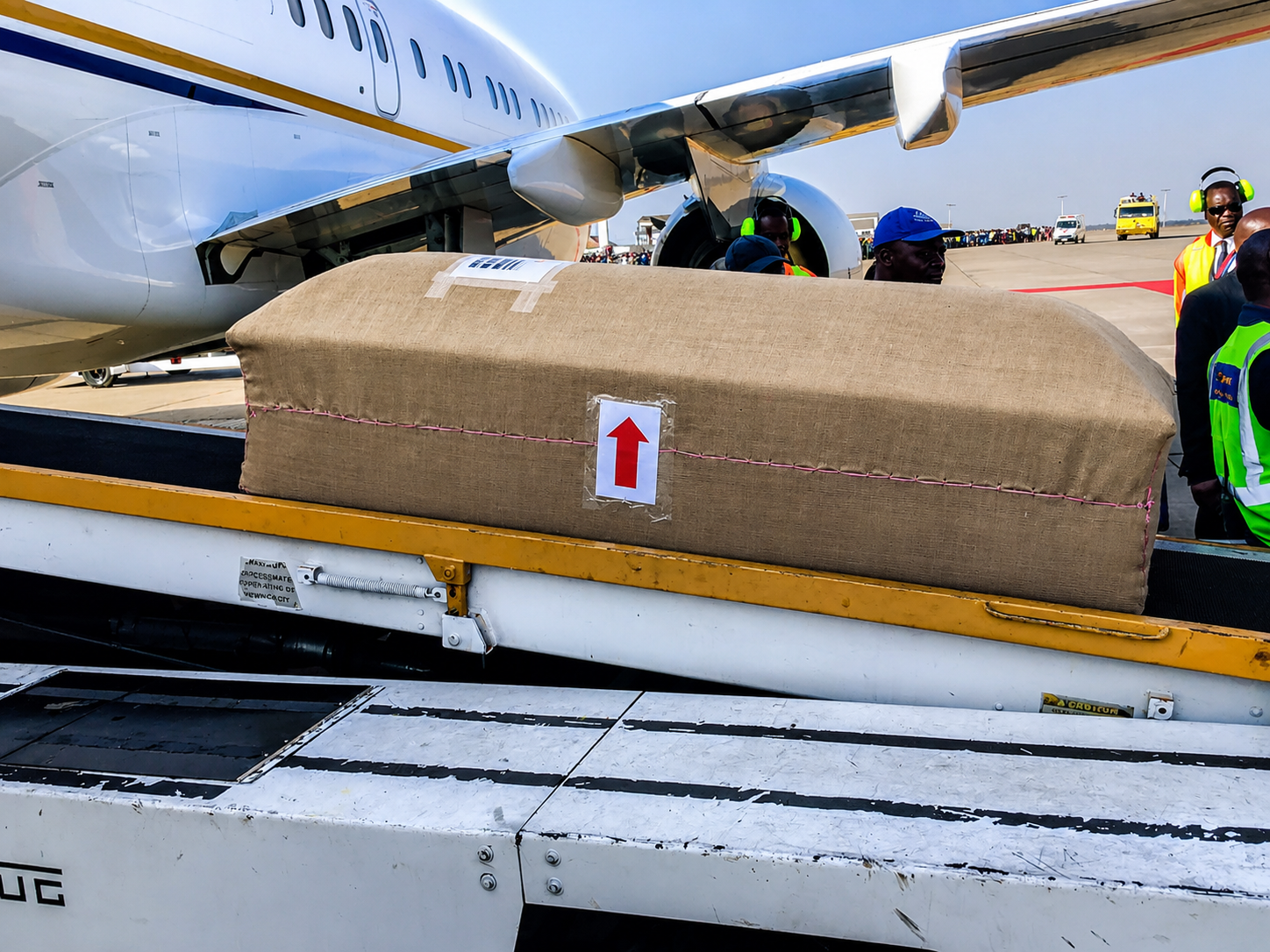 Wrapped casket being loaded onto a cargo aircraft for international repatriation